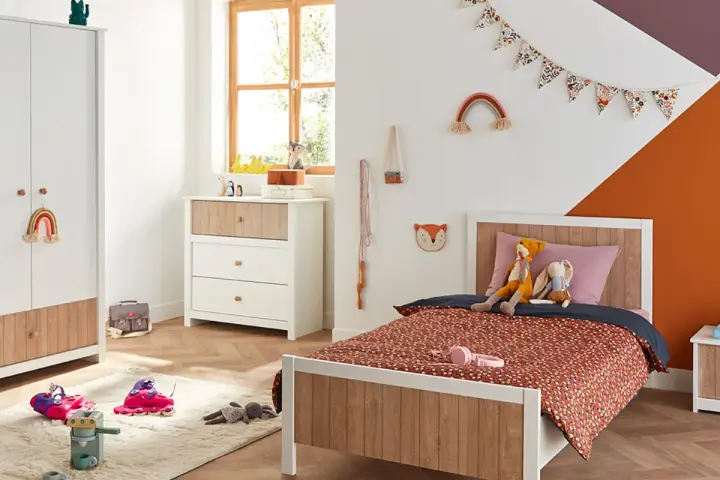 Chambre d'enfant décorée avec un lit, une commode, une armoire et des jouets.
