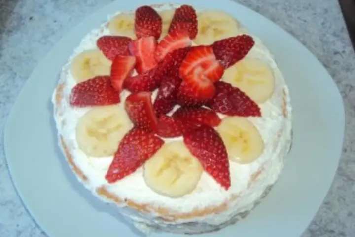 Eine leckere Erdbeer-Bananen-Torte mit viel Sahne und frischen Früchten, perfekt für den Sommer.