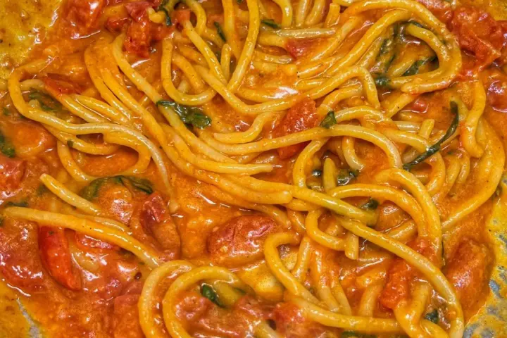 Spaghetti avvolti in un sugo cremoso di pomodoro e basilico, un invitante piatto di pasta allo scarpariello.