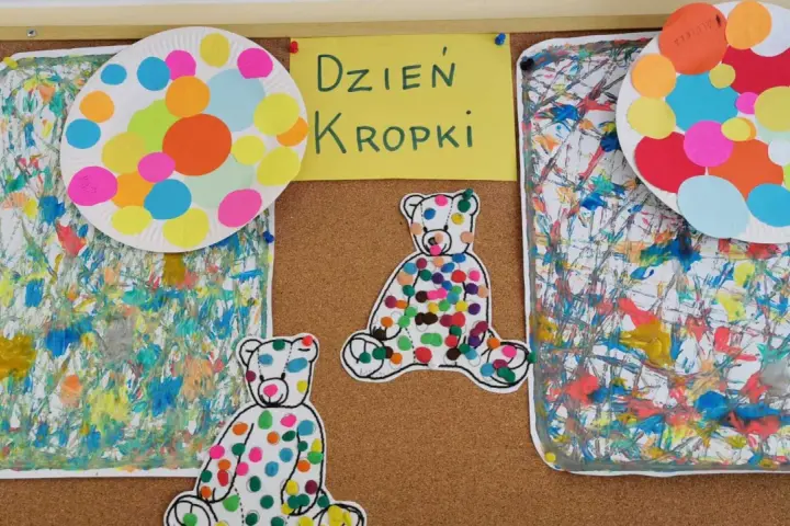 Kolorowe misie i talerze ozdobione kropkami na tablicy. Dzieci tworzyły wspaniałą pracę z kropek, celebrując Dzień Kropki.