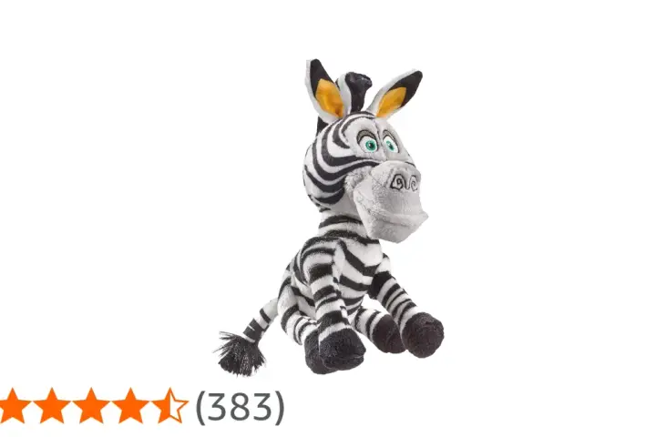 Pluszowa zebra z Madagaskaru, Marty, siedzi z szeroko otwartymi oczami i uśmiechem.