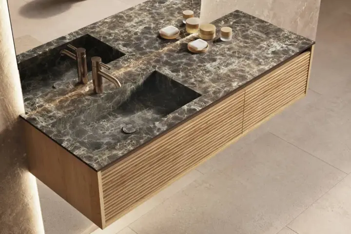 Élégante salle de bain marbre avec double vasque, robinetterie dorée et meuble en bois texturé.