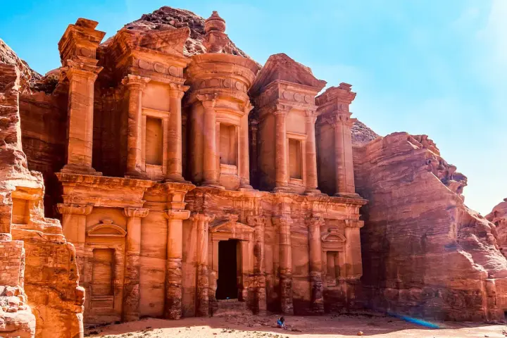 Le Monastère d'Ad-Deir, un trésor de Petra en Jordanie, se dresse majestueusement sculpté dans la roche ocre sous un ciel bleu éclatant.