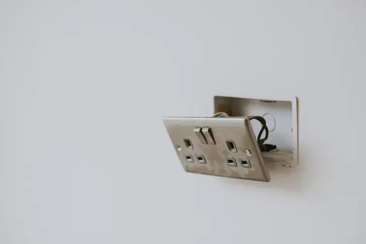 Enchufe con interruptor abierto, mostrando cables. Guía visual para como conectar un enchufe interruptor y bombilla.