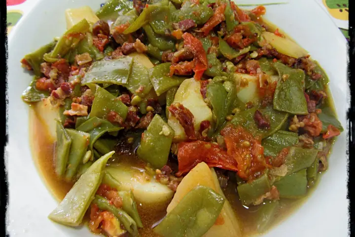 Judías verdes tiernas con patatas y trocitos de jamón, cocinadas en olla express. Un plato casero y delicioso.