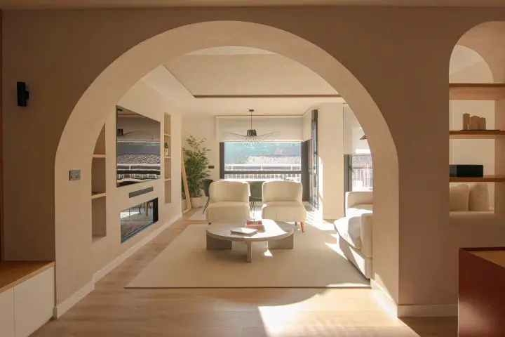 Amplio salón con entrada recibidor integrado. Dos sillones blancos, mesa de centro y sofá invitan a la relajación.