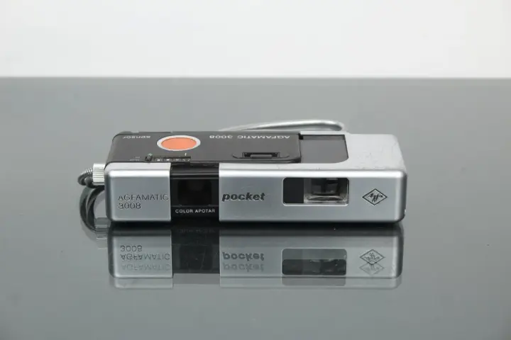 Srebrny aparat Agfamatic 3008 z napisem "pocket" i logo Agfa. Idealny do uchwycenia wspomnień.