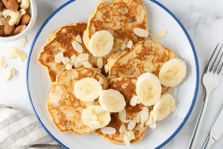 Deliciosas tortitas de plátano, cubiertas con rodajas de plátano y almendras laminadas. Un desayuno perfecto.