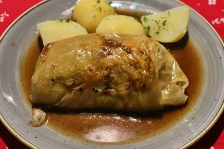 Pyszne gołąbki z kaszą gryczaną w sosie, podane z ziemniakami.