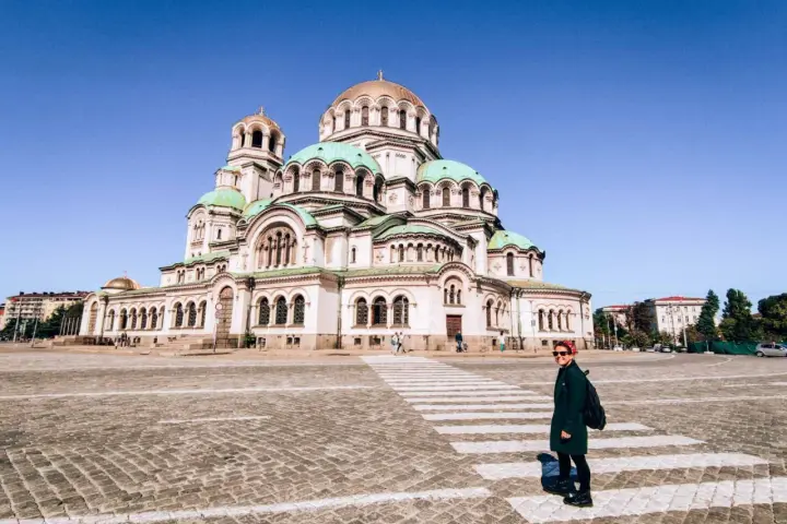 Una donna attraversa la strada davanti alla maestosa Cattedrale Alexander Nevsky, un'icona di cosa fare a Sofia.