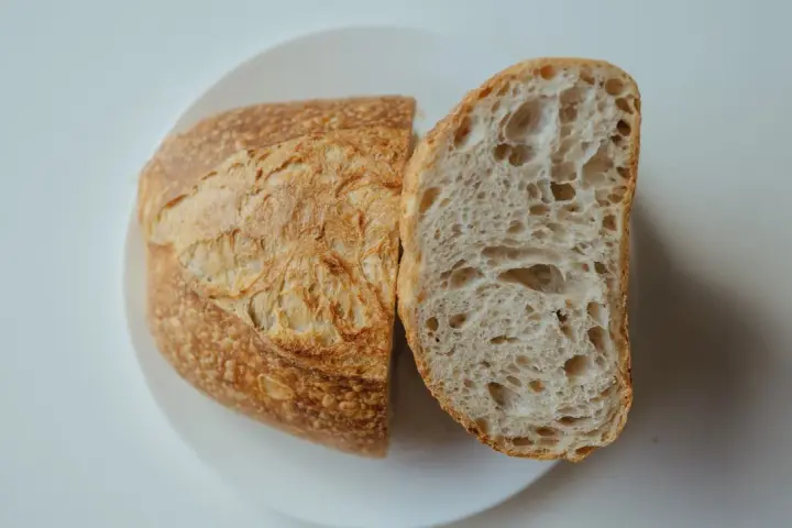 Chleb na talerzu, przekrojony na pół. Idealny przepis na szybki chleb, z chrupiącą skórką i puszystym wnętrzem.