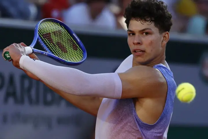 Ben Shelton, a joven tenista, golpea la pelota. Su edad es un factor clave en su prometedora carrera.