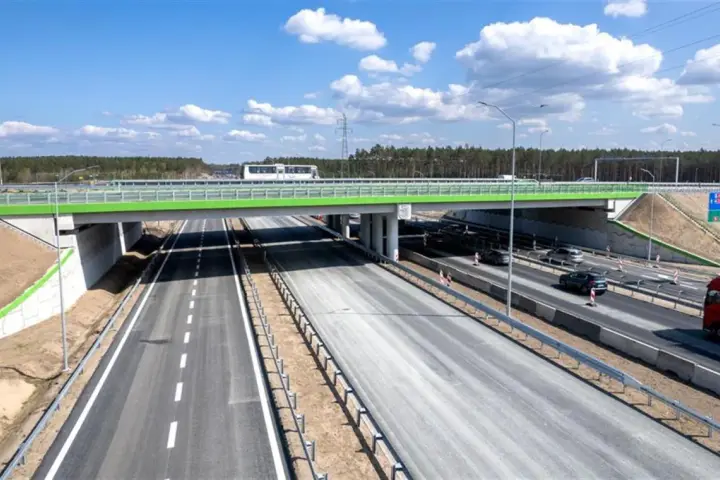 Nowa autostrada A6 z zielonym wiaduktem i ruchem samochodowym.