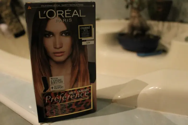 Pudełko farby L'Oréal Préférence z efektem czarne włosy ombre. Modelka na opakowaniu ma włosy w odcieniach brązu i blondu.
