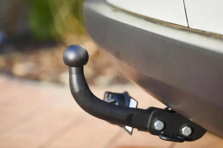 Gancio traino nero montato sul paraurti di un'auto, pronto per il traino secondo il codice della strada.
