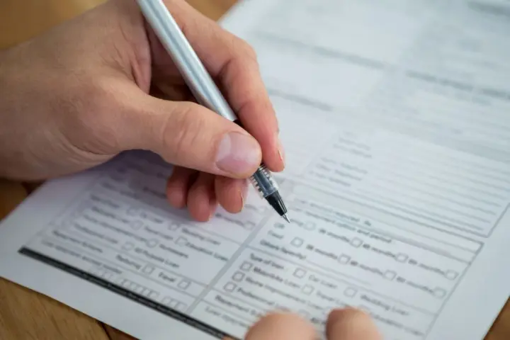 Dłoń z długopisem wypełnia formularz. Warto wiedzieć, jak znaleźć numer NIP, by poprawnie uzupełnić dokumenty.