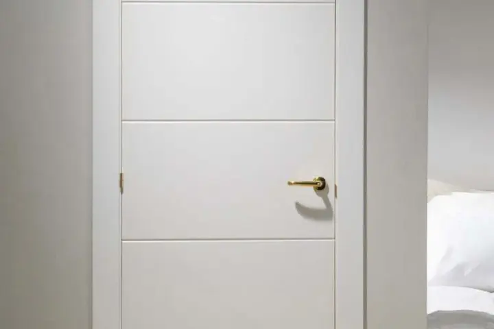 Puerta lacada en blanco con tirador dorado. Aprende como limpiar puertas lacadas en blanco para mantenerlas impecables.
