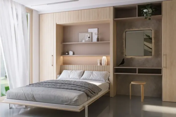 Habitaciones muy pequeñas, pero acogedoras. Cama doble con ropa de cama gris, estantes empotrados con decoración y un espejo iluminado.