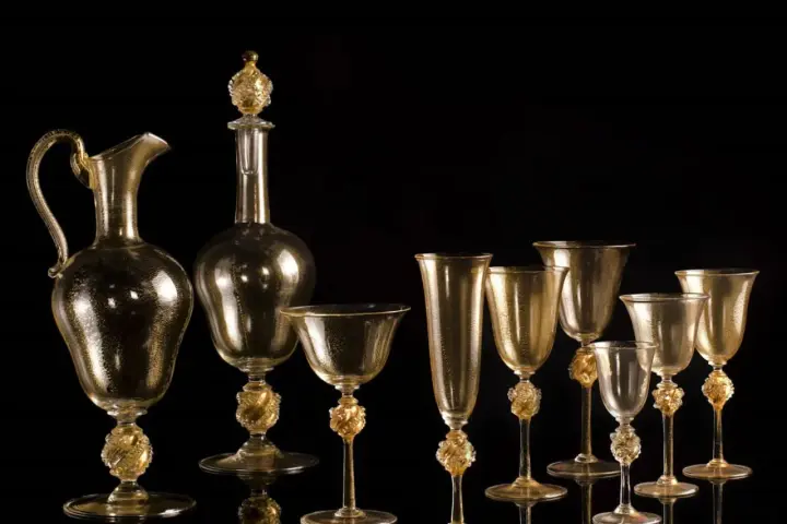 Servizio in vetro di Murano dorato, con decorazioni a foglia d'oro. La maestria nella lavorazione del vetro, che richiede un'accurata gestione della temperatura fusione vetro Murano, crea questi capolavori.