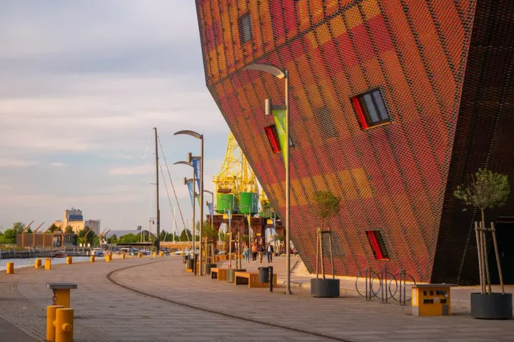 Nowoczesna architektura i portowe klimaty – to właśnie co można zwiedzić w Szczecinie. Widok na nabrzeże z charakterystycznym budynkiem.