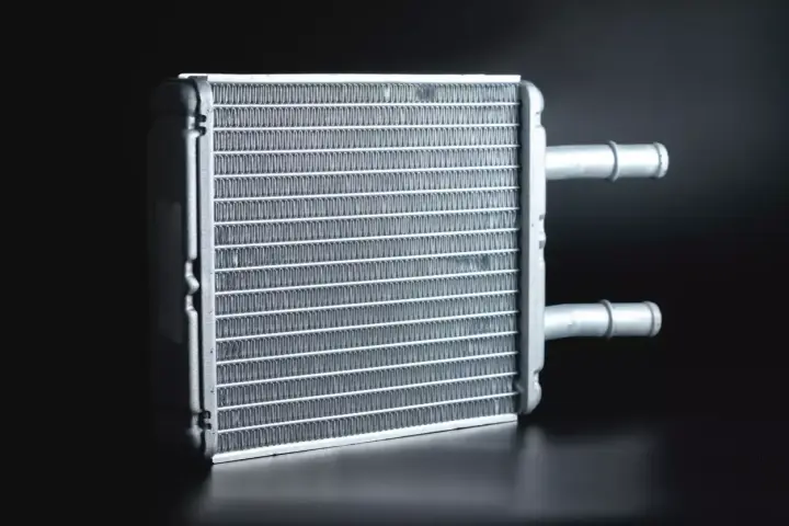 A new heater core, essential for a heater core replacement, sits ready for installation. Its fins are clean and ready to warm your car.