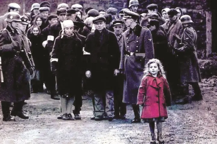 Dziewczynka w czerwonym płaszczu na tle sceny z filmu "Lista Schindlera".