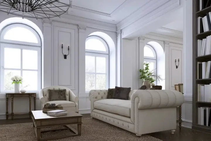 Elegancki salon z sofą, fotelem i książkami na półce.