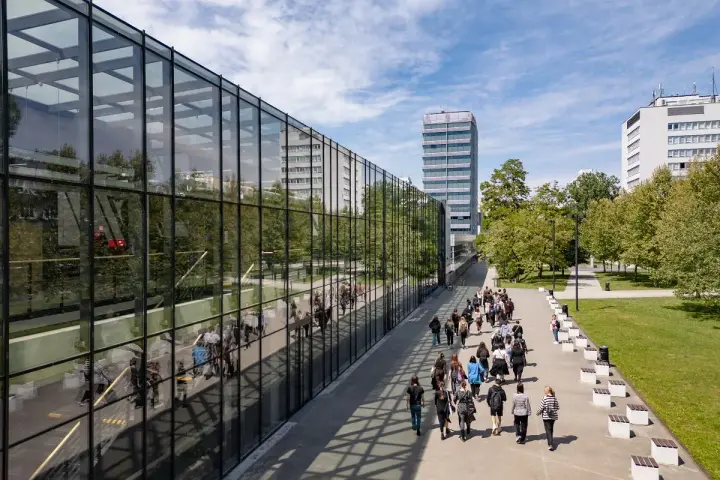Studenci idący nowoczesnym kampusowym chodnikiem, gdzie odbywają się studia artystyczne Wrocław.