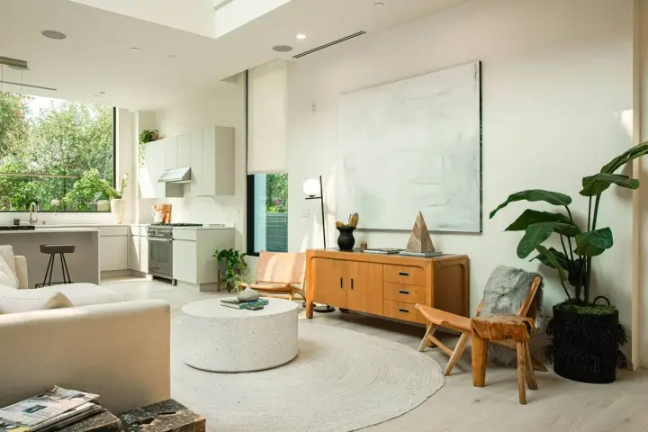 Un salón luminoso con cocina integrada, muebles de madera clara y decoración minimalista, reflejando un estilo nordico casa.