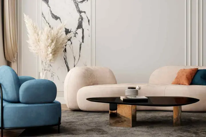 Un divano beige dalle forme morbide crea un'atmosfera accogliente, con abbinamenti di cuscini in terracotta e blu.