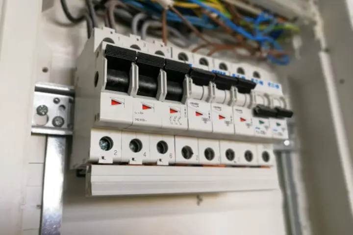 W rozdzielnicy elektrycznej widać rzędy bezpieczników automatycznych, każdy oznaczony numerem, np. c16.