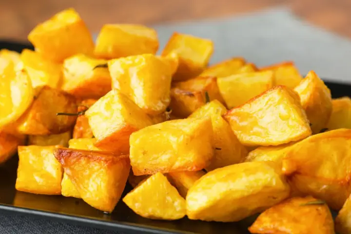 Un mucchio invitante di patate al forno croccanti, dorate e profumate, pronte per essere gustate.