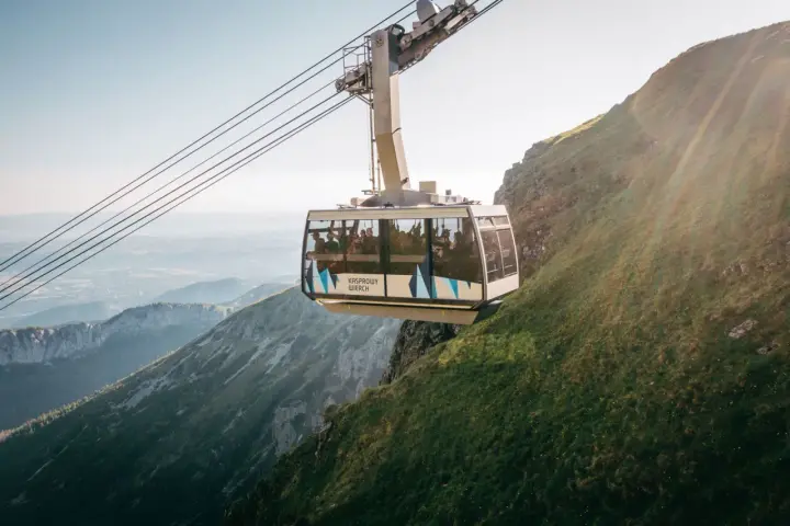 Kolejka na Kasprowy Wierch wwozi turystów na szczyt. Widok z wagonika zapiera dech w piersiach, ukazując malownicze Tatry.