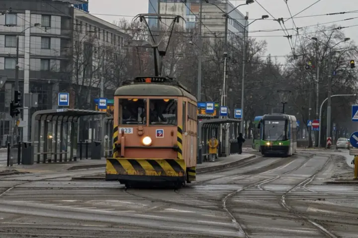 Gdy pada w Szczecinie, można wsiąść do tramwaju i podziwiać miasto z okna. Dwa tramwaje na torach, jeden pomarańczowy, drugi zielony.