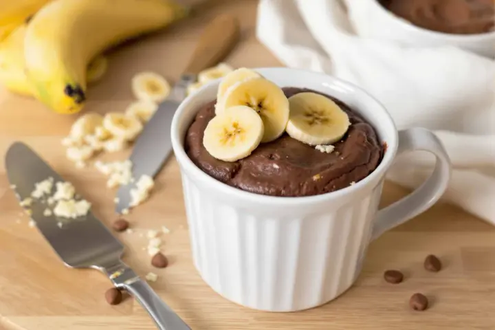 Un délicieux mug cake banane au chocolat, garni de rondelles de banane fraîche. Parfait pour une envie gourmande rapide.