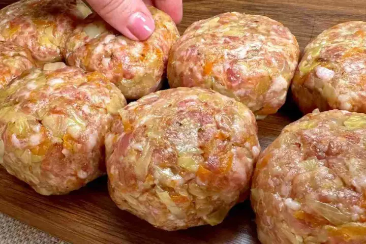 Mani che preparano polpette in bianco, un impasto di carne macinata con verdure, pronte per essere cucinate.