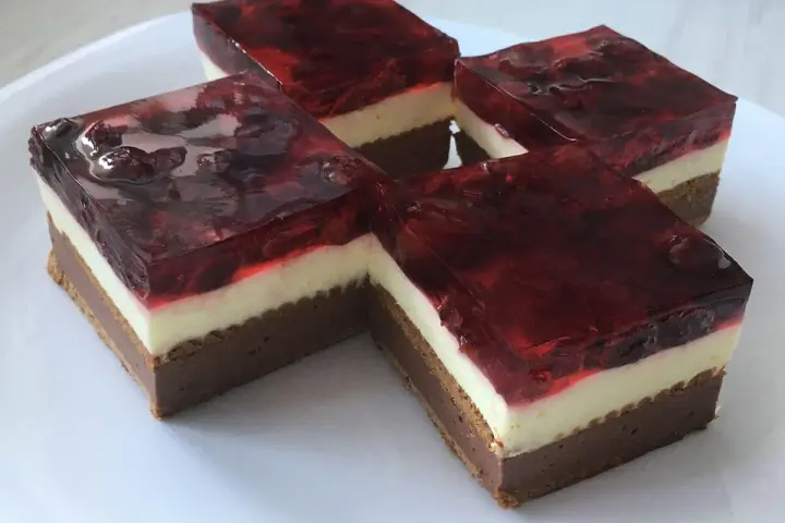Proste ciasto z serkiem mascarpone i galaretką wiśniową, ułożone na białym talerzu.