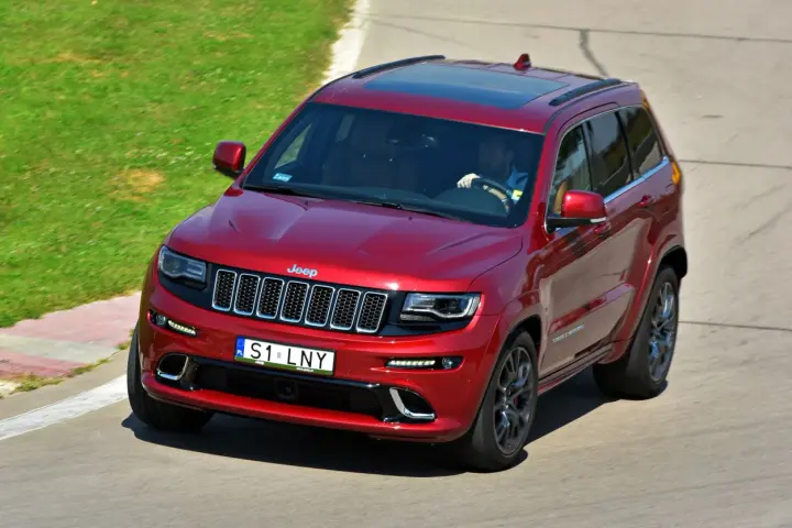 Czerwony Jeep Grand Cherokee na torze. Zastanawiasz się, ile kosztuje personalizowana rejestracja, gdy widzisz tablicę S1 LNY?