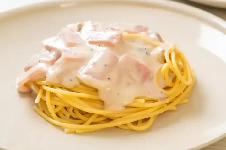 Pyszne spaghetti z kremowym sosem, kawałkami szynki i pieprzem. Idealne makaron po toskańsku na szybki obiad.