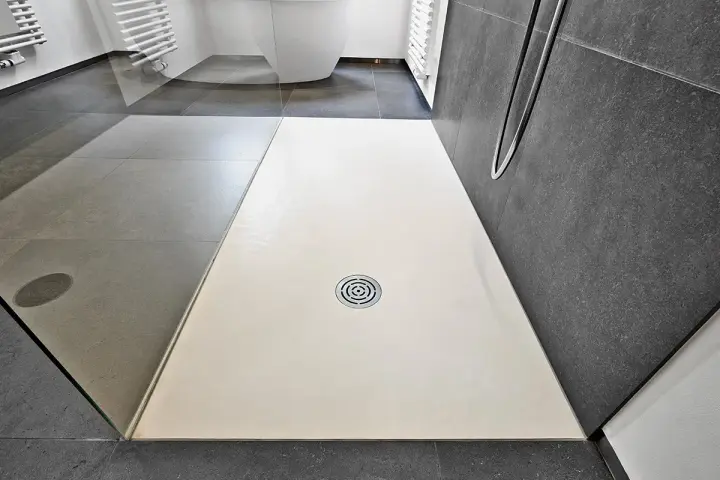 Receveur de douche blanc, quelle matière choisir pour un style moderne ? Sol gris, paroi sombre.