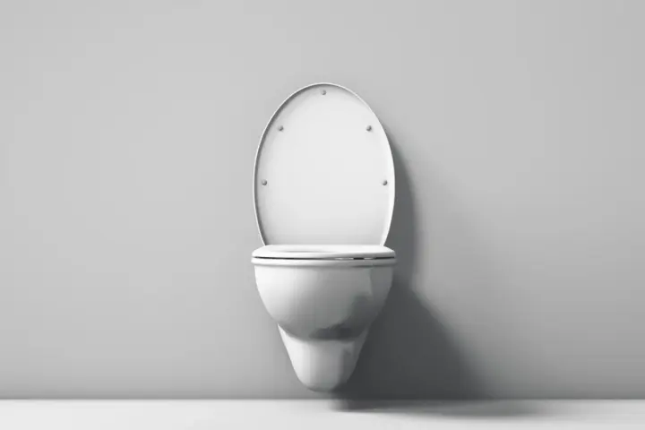 Biała, wisząca miska WC z klapą z duroplastu, zamontowana na szarej ścianie.