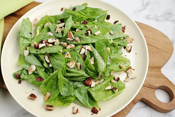 Frischer Spinatsalat mit gehackten Nüssen, ein einfaches und leckeres spinatsalat rezept.
