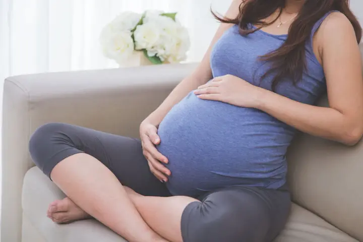Donna incinta accarezza il pancione, pensando alla possibile perdita del tappo mucoso durante la gravidanza.
