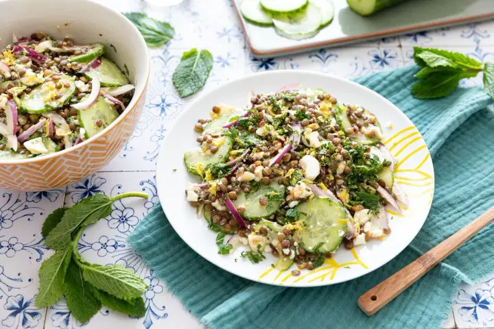 Salade de lentilles, concombre, oignon rouge et feta émiettée, garnie d'herbes fraîches. Un délice léger et coloré.