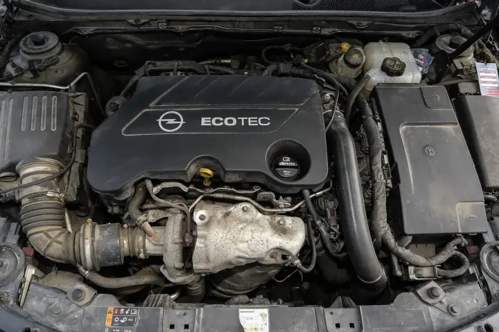 Silnik Opel Ecotec. Widoczne elementy układu dolotowego i turbosprężarki. Objawy uszkodzenia poduszki silnika mogą być różne, np. wibracje.
