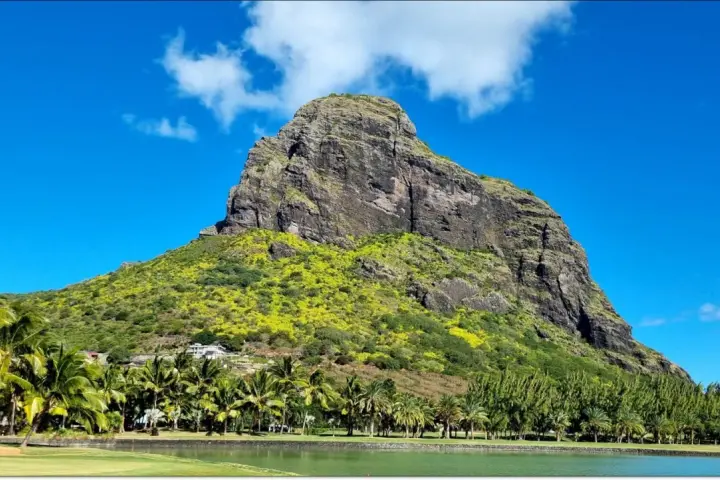 Mauritius pogoda marzec: majestatyczna góra porośnięta zielenią, palmy, jezioro i błękitne niebo.
