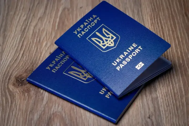 Dwa niebieskie paszporty Ukrainy leżą na drewnianym tle. Czy do Turcji potrzebny jest paszport? Tak, do podróży do Turcji potrzebny jest paszport.