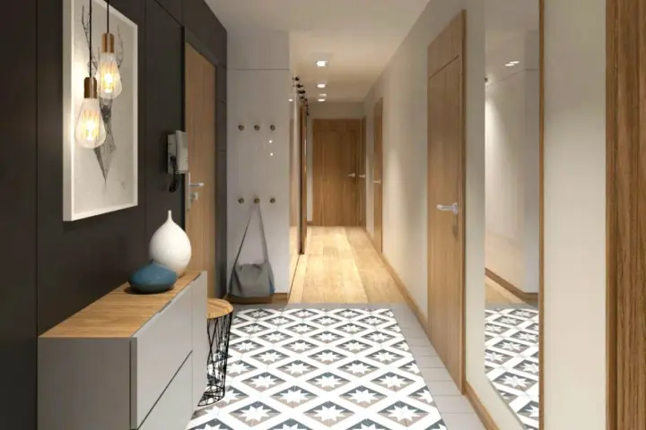 Un corridoio stretto con un tappeto geometrico, mobili moderni e un quadro astratto. Idee per un corridoio che unisce funzionalità ed estetica.