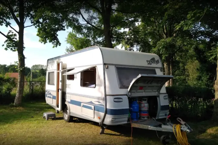 Przygotowania do wypoczynku na **camping Duszniki Zdrój**. Przyczepa kempingowa z otwartym bagażnikiem, w którym widać butle gazowe.