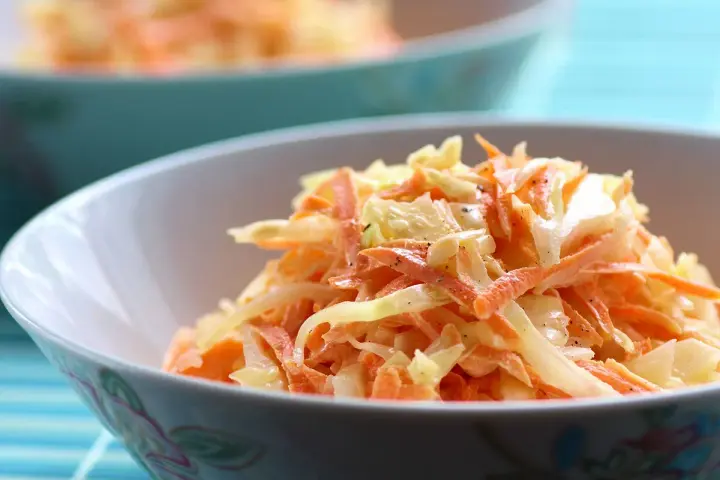 Un bol de véritable sauce coleslaw, mélange frais de chou râpé et de carottes, assaisonné de poivre noir.